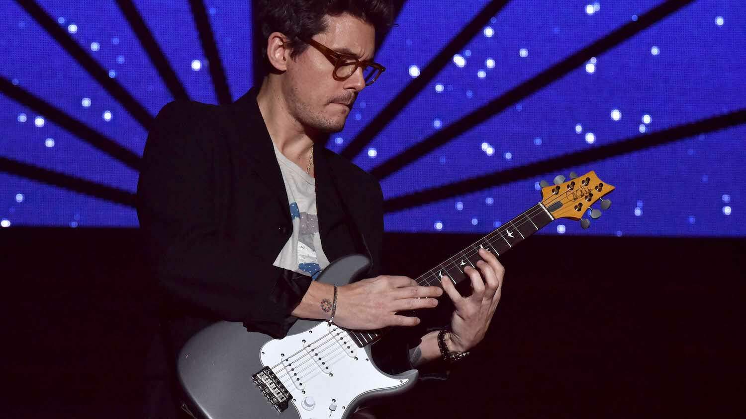 John Mayer se apresentando no palco com sua guitarra signature da PRS