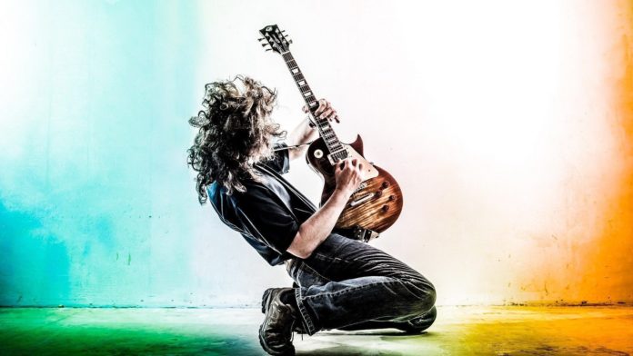 guitarist-concurso-guitarrista-do-ano-2018 Guitarrista tocando ajoelhado no palco.