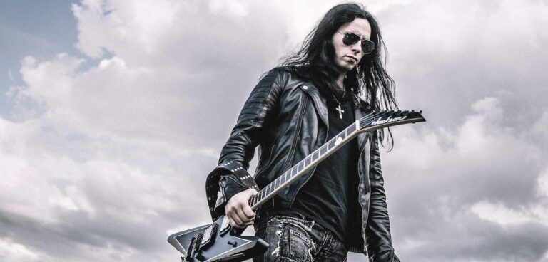 Gus G. segurando uma guitarra Jackson