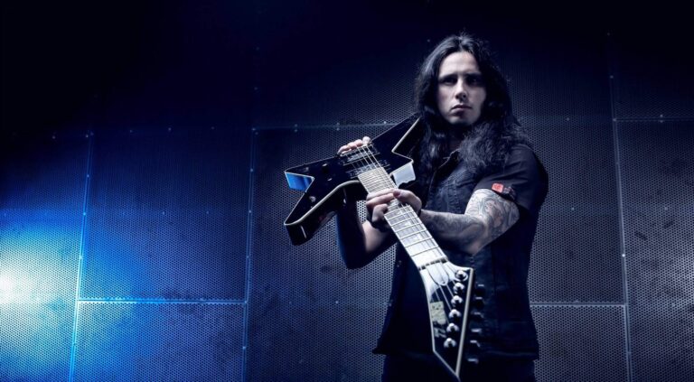 Gus G. posando para foto com uma guitarra