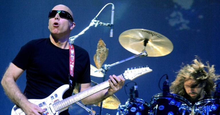 Joe Satriani com uma bateria ao fundo