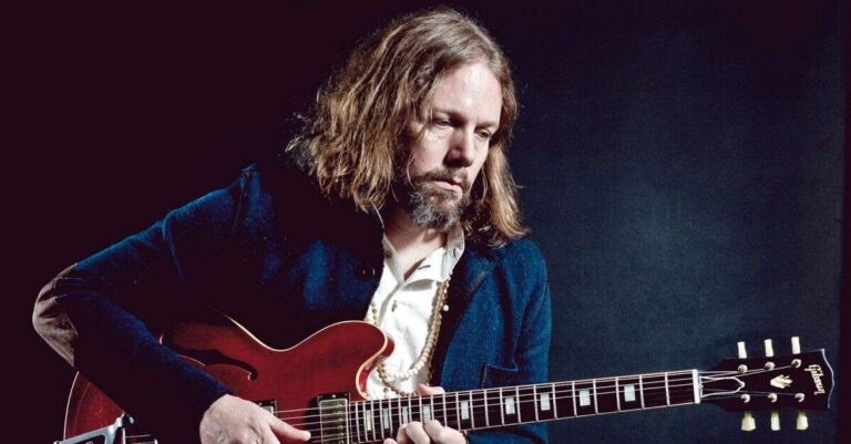 Rich Robinson com uma guitarra vermelha