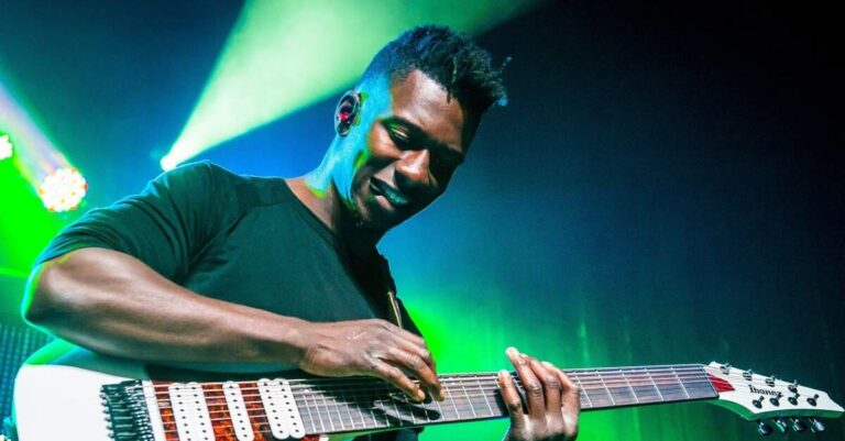 Tosin Abasi tocando uma guitarra Ibanez