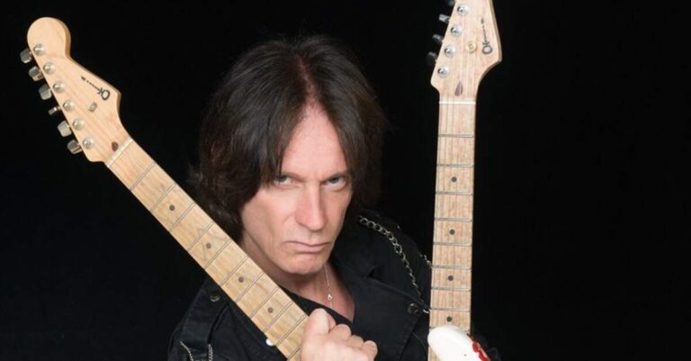 Chris Impellitteri segurando duas guitarras