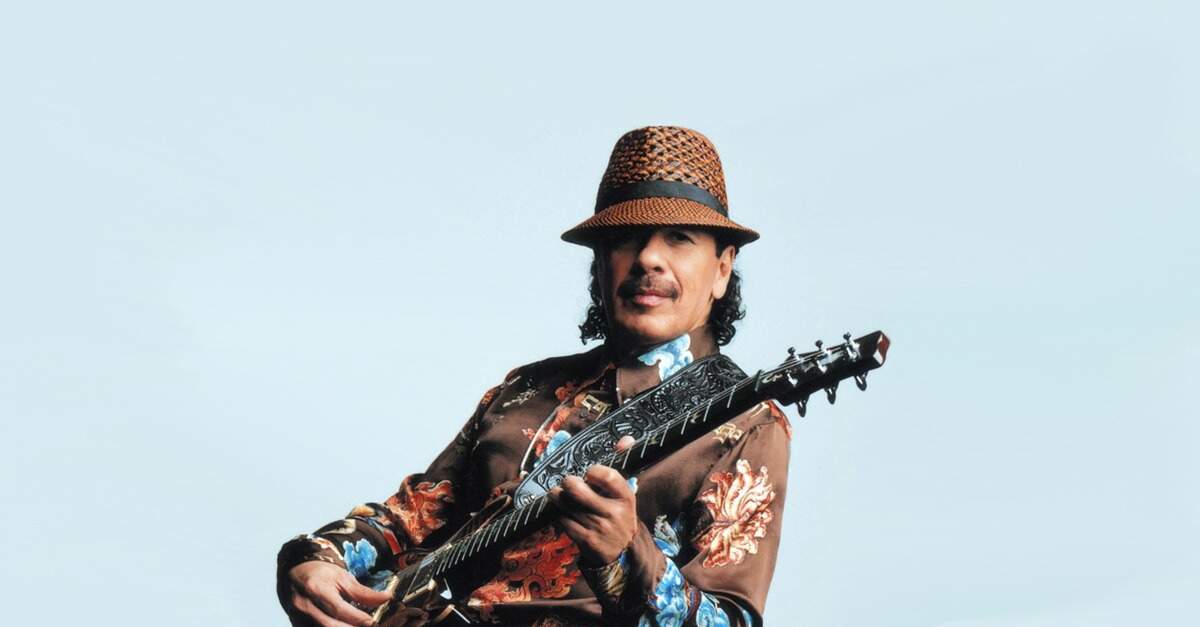 Santana posando para foto com uma guitarra PRS