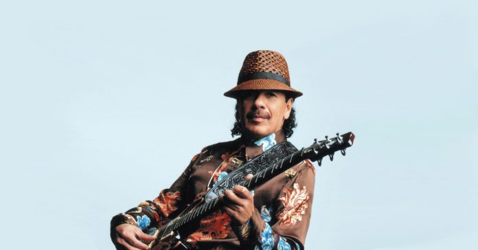 santana Santana posando para foto com uma guitarra PRS