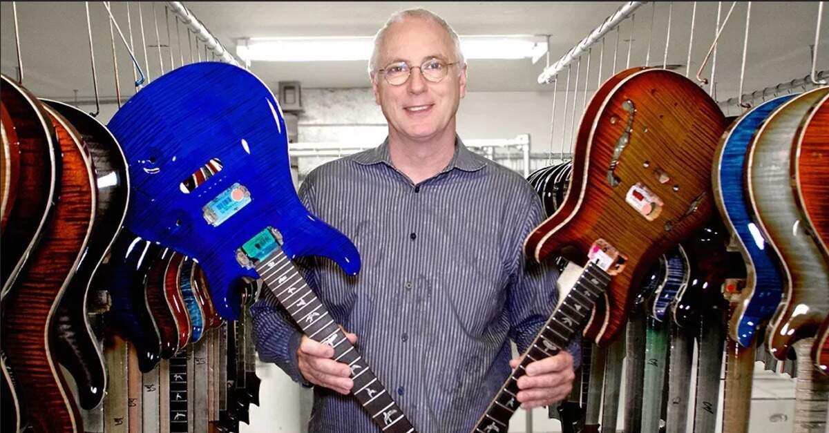Paul Reed Smith segurando duas guitarras PRS