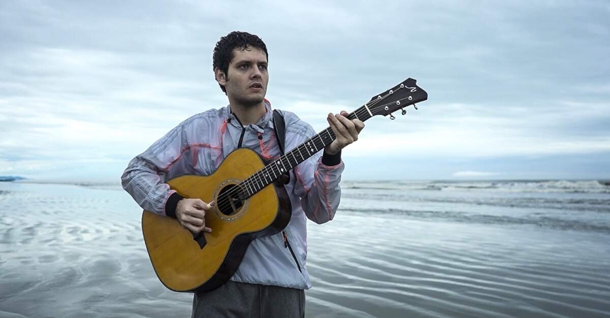 Daniel Padim tocando violão na praia