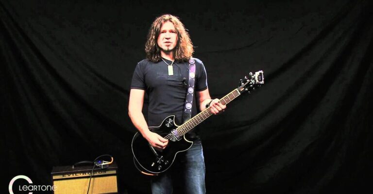 Phil X com uma guitarra preta