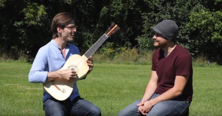 Homem segurando uma guitarra barroca