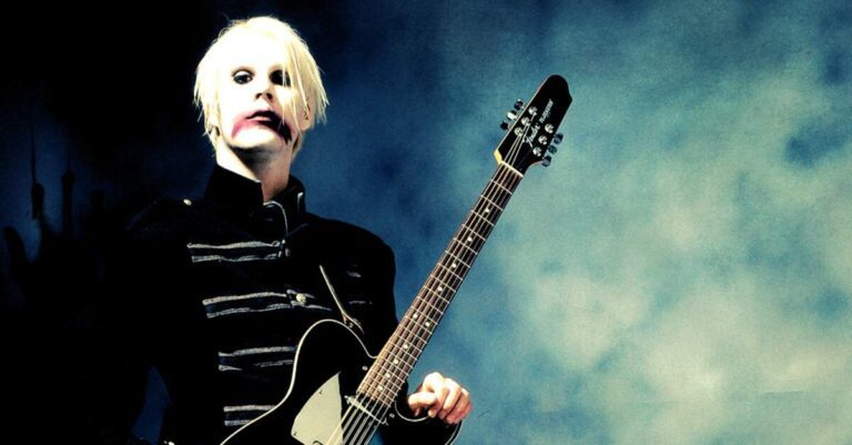 John 5 posando para foto com uma guitarra preta